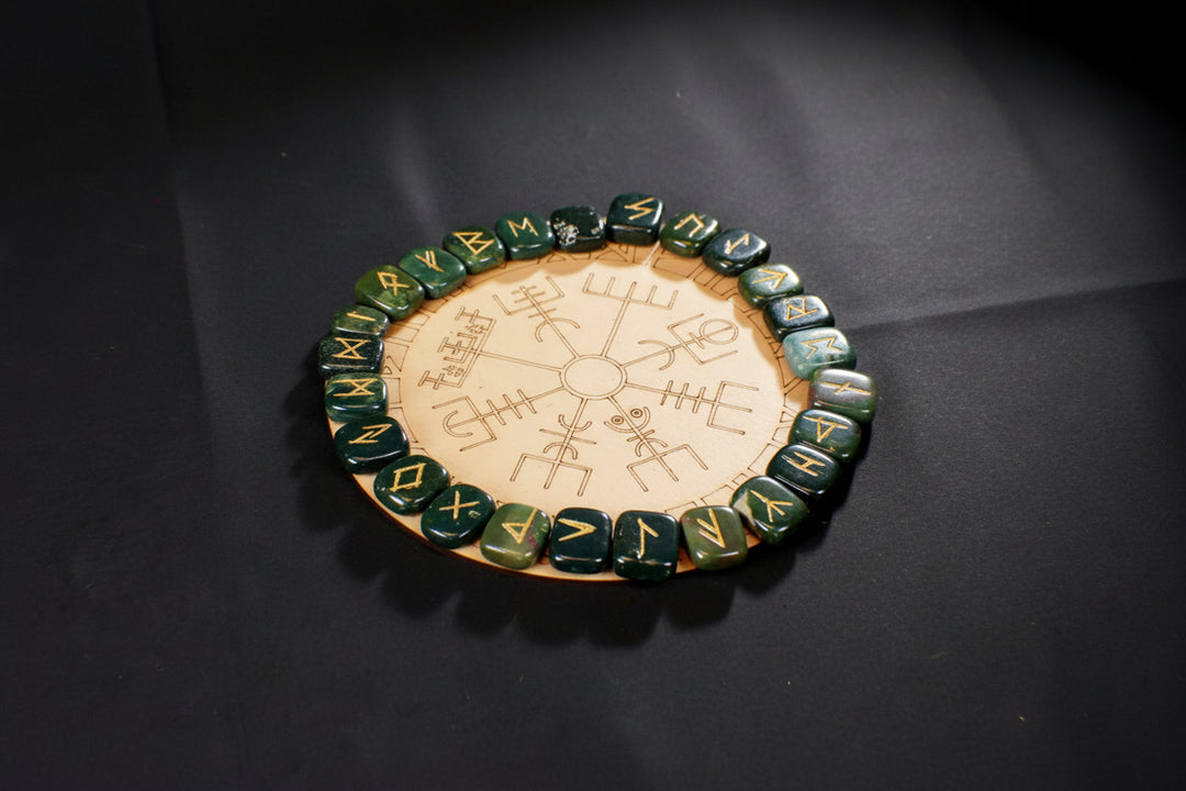 Engraved Bloodstone rune pieces arranged on a matching casting board