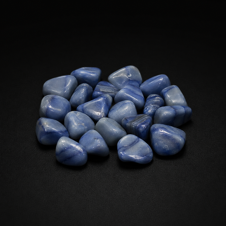 Polished blue stones sold as Blue Aventurine with cloudy blue banding on a matte black surface
