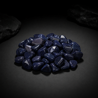 Pile of polished deep blue Goldstone tumbled glass with fine metallic sparkle on a dark surface