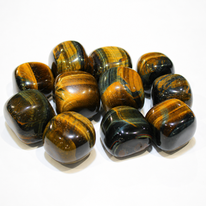 Polished Blue Tiger Eye stones with blue-green, golden-brown, and black chatoyant bands on white