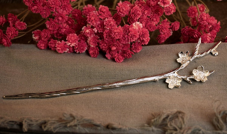 Silver cherry blossom hair pin on a grey cloth
