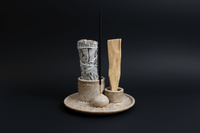 Set of natural cleaning tools on a textured round stand with a white background