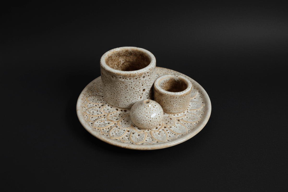 Ceramic incense holder with three cylindrical compartments on a white background