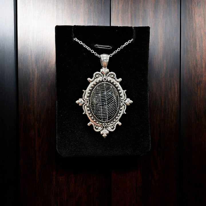 Alternate view of silver-tone filigree cabochon containing spiderweb