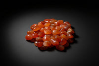Representative polished orange-to-red stones sold as Carnelian; color, translucency, shape, and size vary