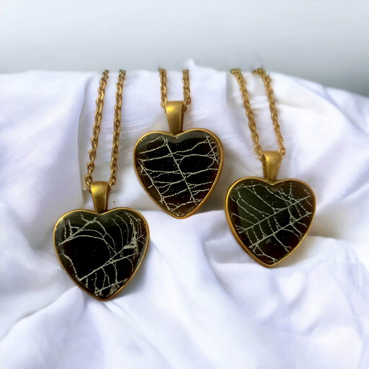 Heart-shaped necklace pendants containing real spiderweb