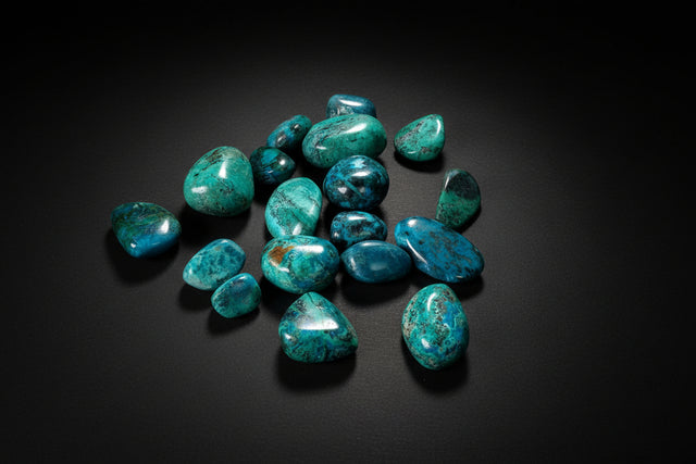 Polished blue-green Chrysocolla tumbled stones with dark matrix