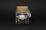 Glass jar with cork lid containing 'Clearing & Unblocking' ritual powder on a white background