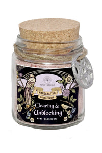 Glass jar with cork lid containing 'Clearing & Unblocking' ritual powder on a white background