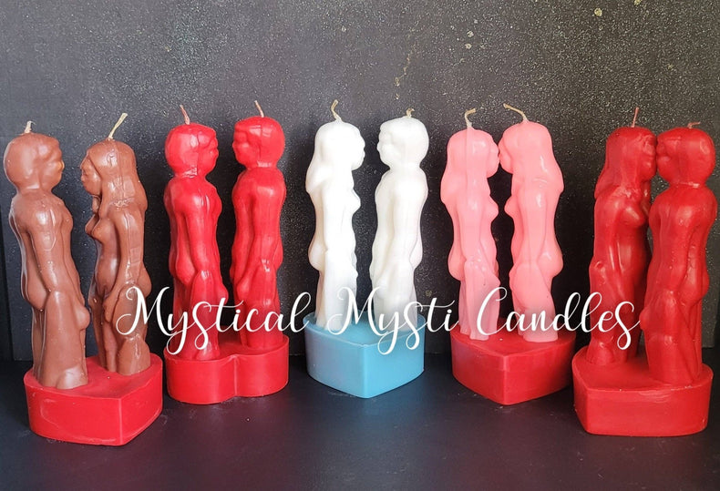 Row of candles shaped like people with 'Mystical Mysti Candles' branding on a dark background.