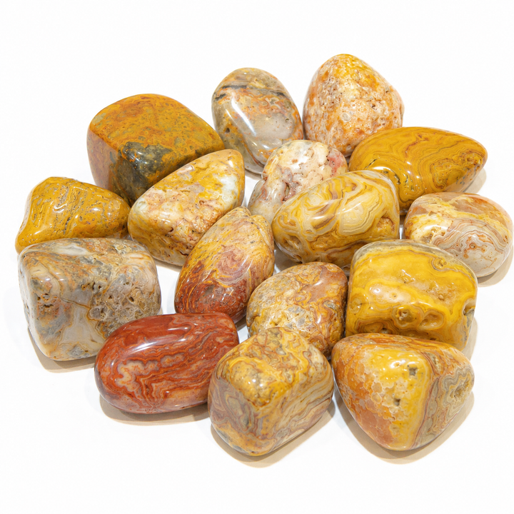 Assortment of polished Crazy Lace Agate tumbled stones with yellow, cream, gray, and red banding on white