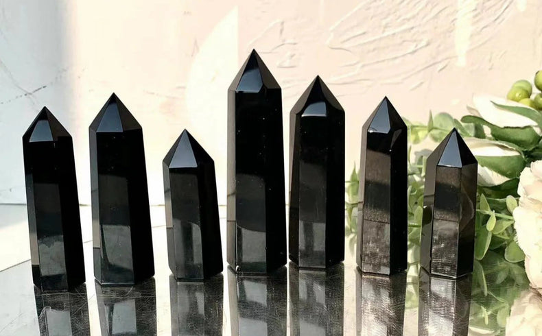 Black crystal points on a reflective surface with 'smcrystalwholesale.com' text above.