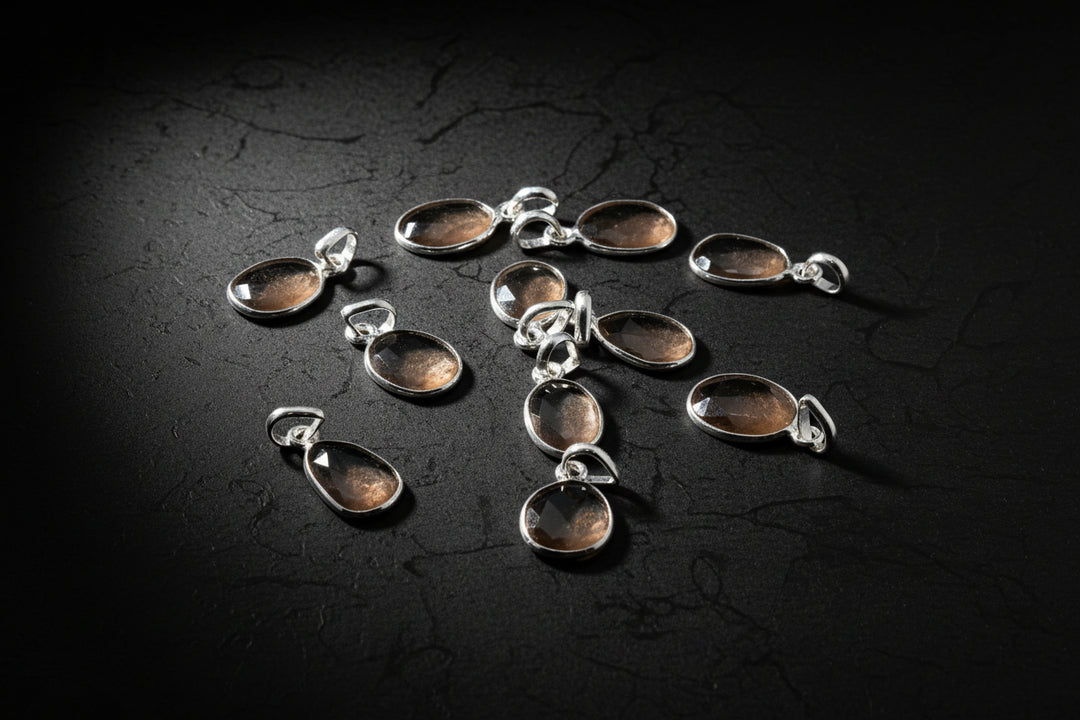 Representative peach moonstone pendant necklaces in silver settings on a black background