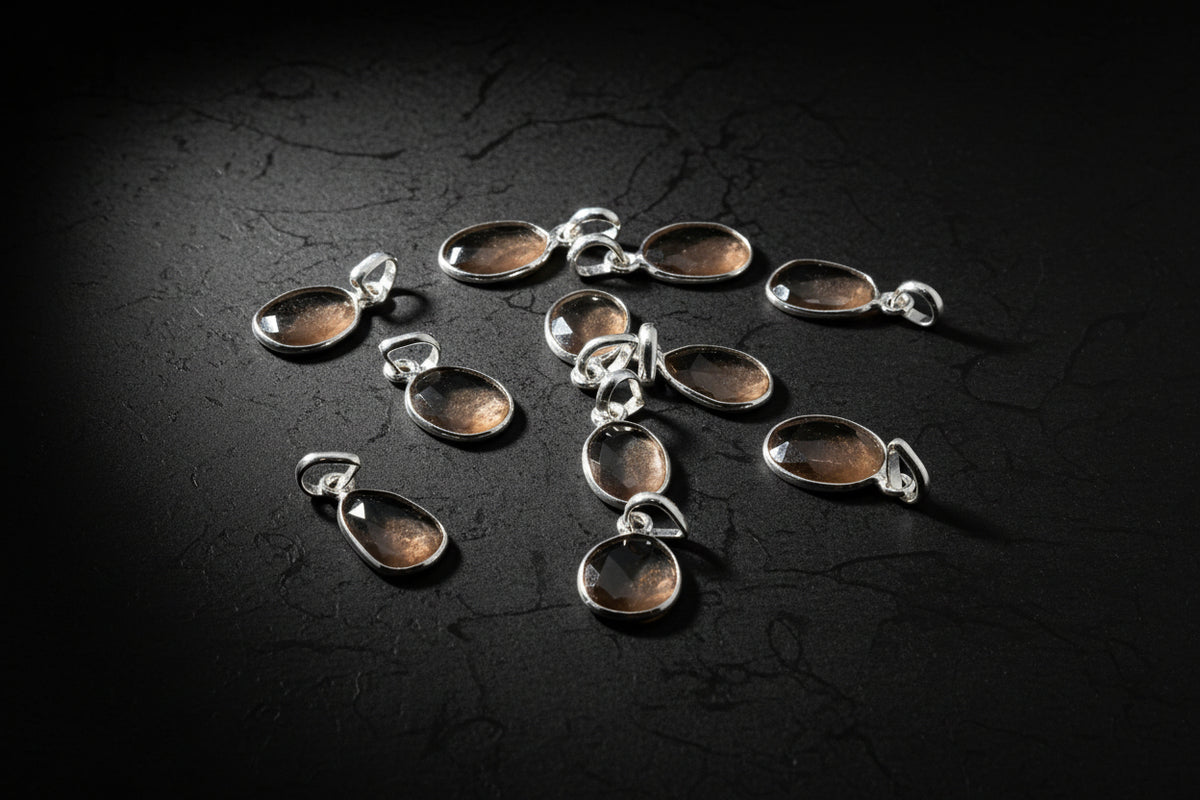 Representative peach moonstone pendant necklaces in silver settings on a black background