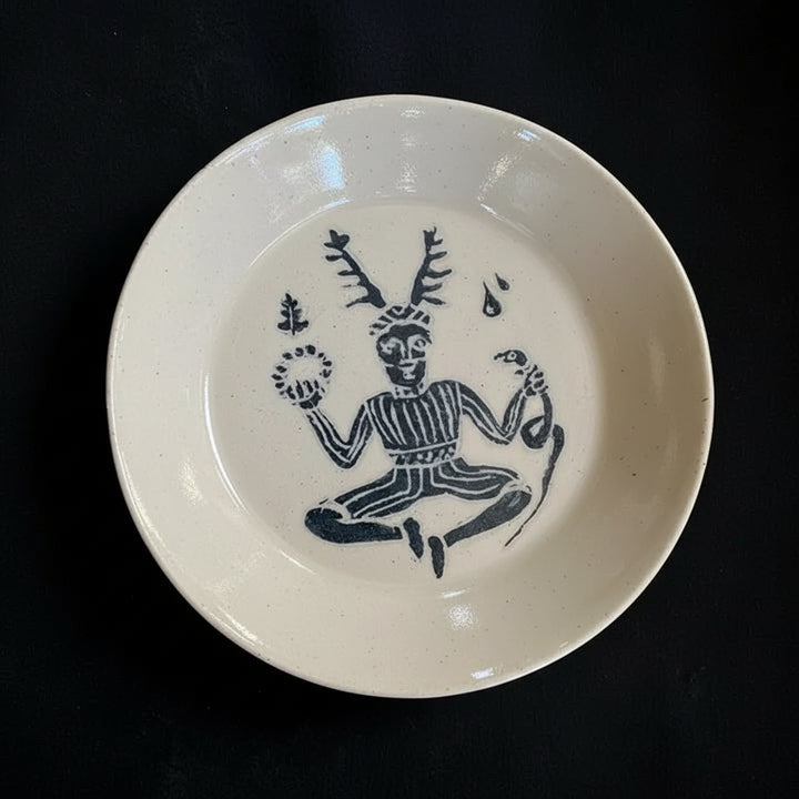 White ceramic plate with black decorative design on a dark background