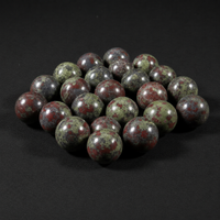 Alternate view of polished green, red, and gray Dragon Stone mini spheres on a matte black background