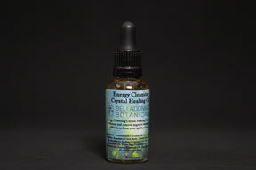 Bottle of Energy Cleansing Crystal Healing Oil with a dropper on a mystical background.
