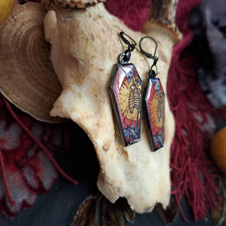 Black Skull and Savior gothic earrings shown as a pair