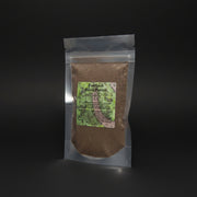 Packaged 'Fast Luck Ritual Powder' from Belladonna's Botanicals on a mystical background with stones and candles.