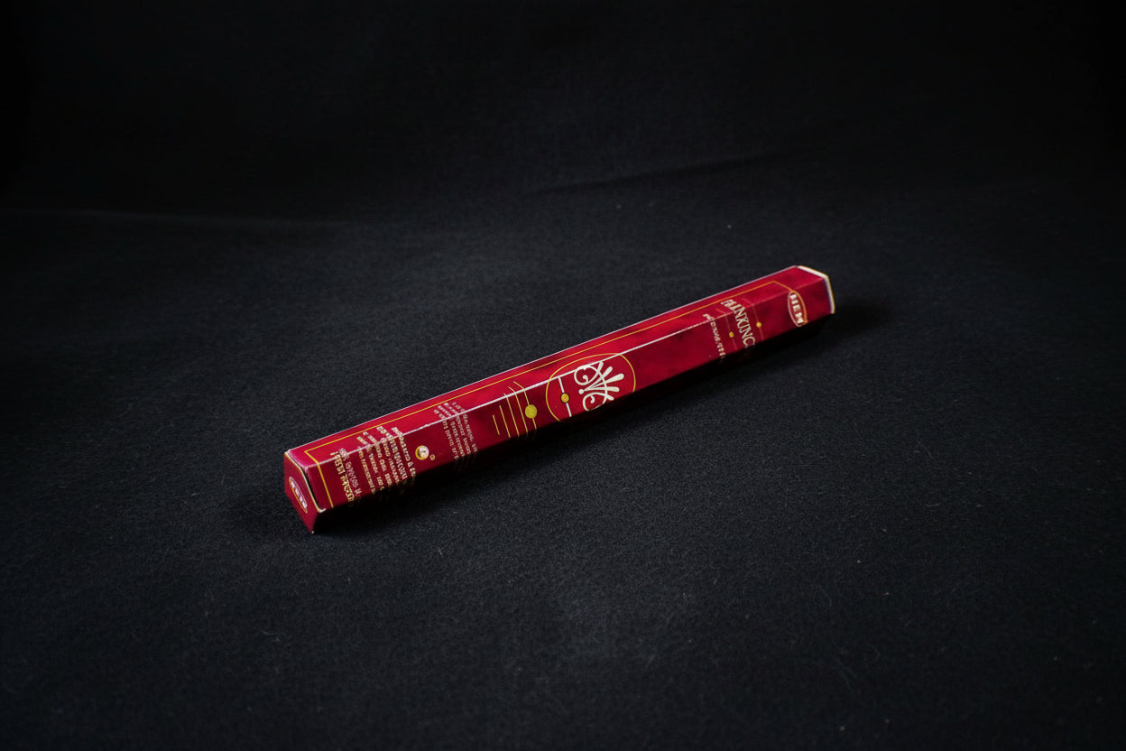 A pack of Frankincense incense sticks placed on a wooden surface, with a decorative box in the background.