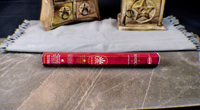 A pack of Frankincense incense sticks placed on a wooden surface, with a decorative box in the background.