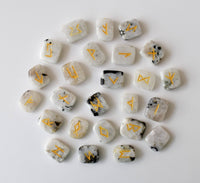 Set of stones with gold runes on a white background