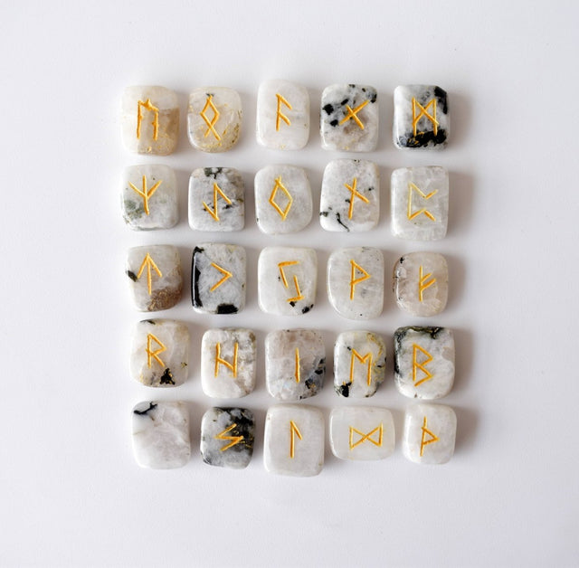 Set of stone runes with gold inscriptions on a white background