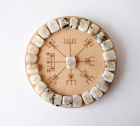 Wooden circle with rune stones arranged around it on a white background