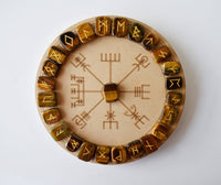 Wooden circular object with engraved symbols on a white background