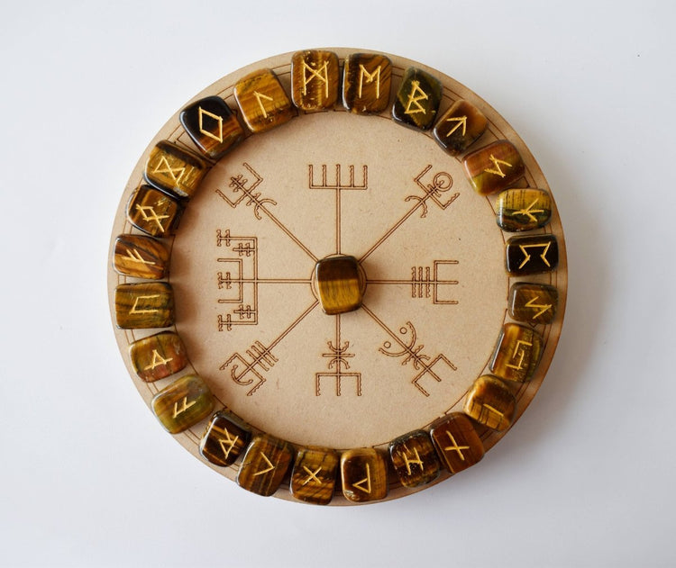 Wooden circular object with engraved symbols on a white background