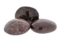 Three dark brown stones on a white background