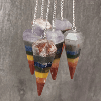 Colorful layered stone pendulums on a gray background