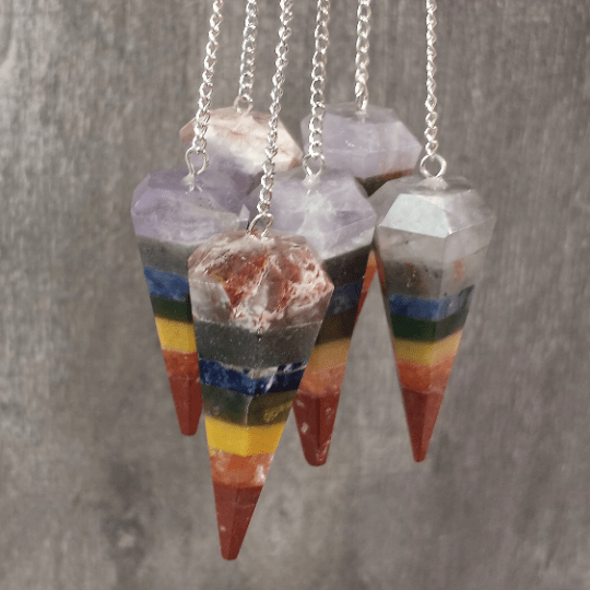 Colorful layered stone pendulums on a gray background