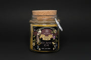 Jar of 'Go Away Evil' ritual powder with decorative label and cork lid on a white background