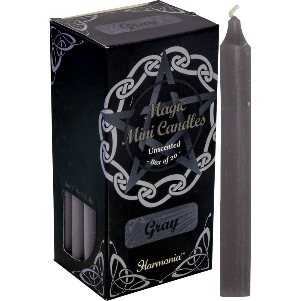 Gray candle next to its packaging with 'Harmonia' branding