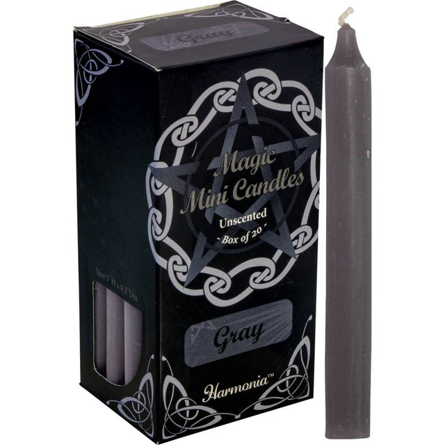 Gray candle next to its packaging with 'Harmonia' branding