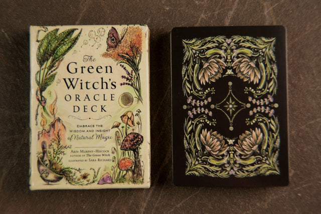 The image shows two views of a tarot deck. The front view features the cover with floral and herbal illustrations, and the title 'The Green Witch's Oracle Deck'.