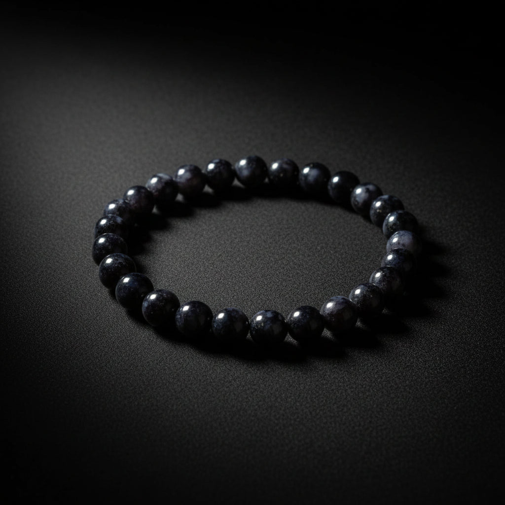 Representative polished beaded stretch bracelet sold as Indigo Gabbro; rock composition, treatment, black-to-gray mottling, bead size, fit, and exact condition vary