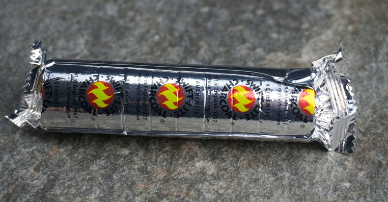 A pack of charcoal discs wrapped in tin foil with a design of a flame on the packaging.