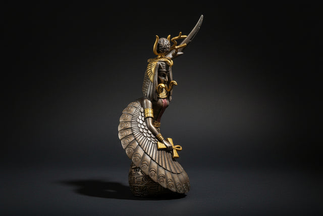 Decorative figurine of a winged creature with gold accents on a white background