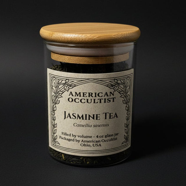 Loose jasmine green tea (Camellia sinensis with jasmine blossoms) in a labeled glass ritual herb jar