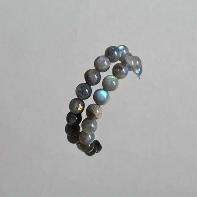 Hand wearing a stack of beaded bracelets on a plain background with 'SM Crystal Wholesale' branding.