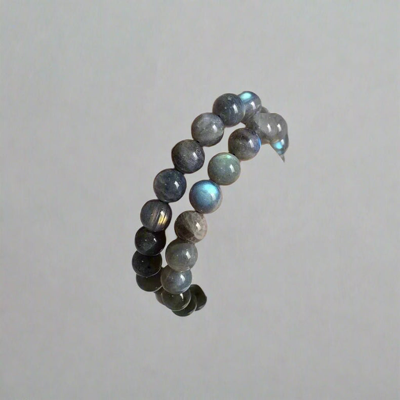 Hand wearing a stack of beaded bracelets on a plain background with 'SM Crystal Wholesale' branding.