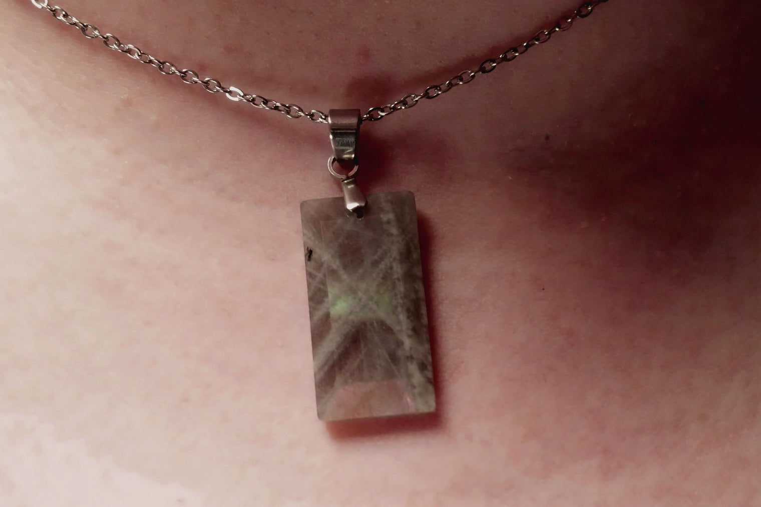 Close-up of Labradorite faceted crystal pendant showing its mystical colors and intricate cut
