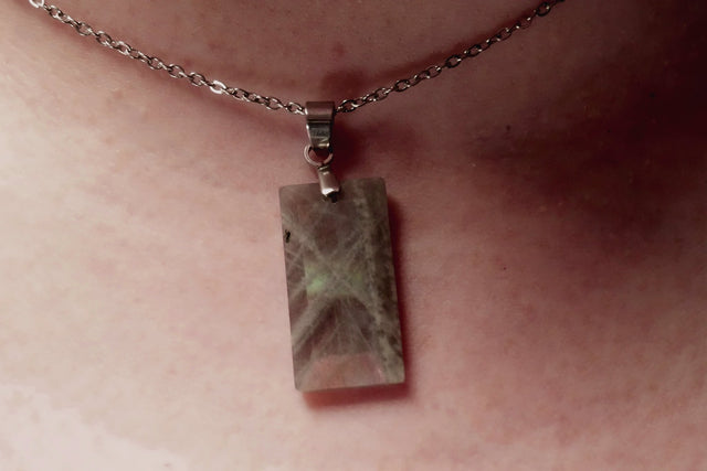 Close-up of Labradorite faceted crystal pendant showing its mystical colors and intricate cut
