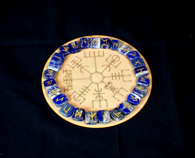 A circular lapis lazuli rune board with a golden pyrite vein pattern and Elder Futhark runic inscriptions.
