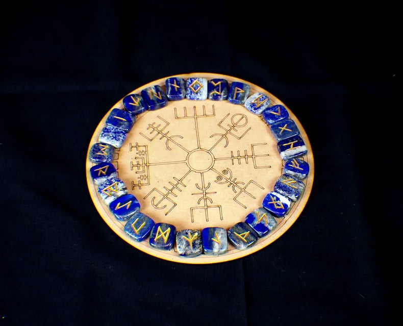 A circular lapis lazuli rune board with a golden pyrite vein pattern and Elder Futhark runic inscriptions.