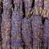 Bundles of dried lavender tied with purple string on a dark background