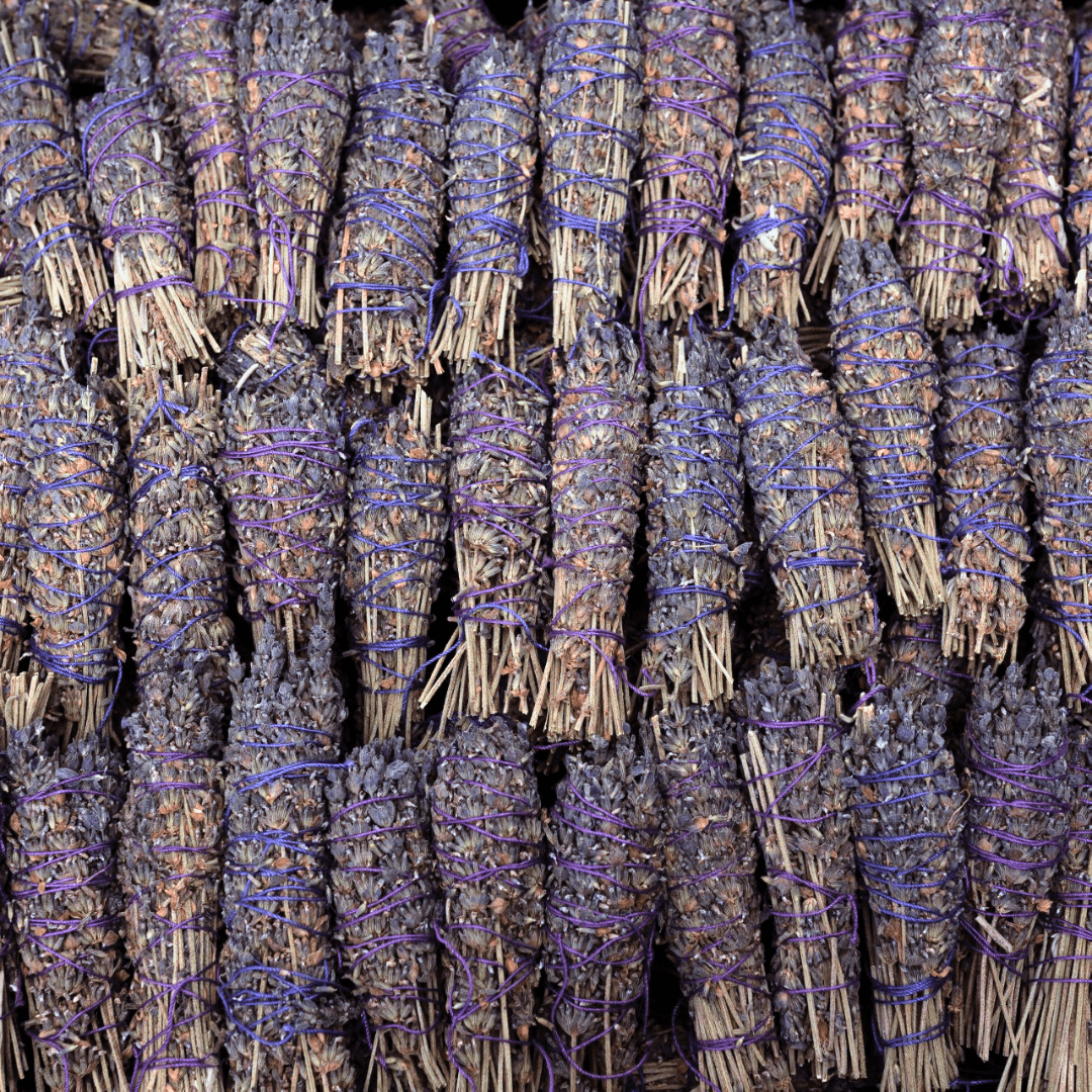 Bundles of lavender smudge sticks tied with purple ribbons.
