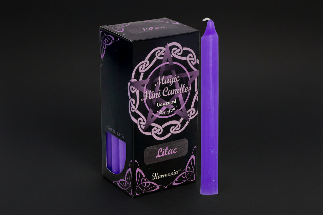 Purple candle next to its packaging with &